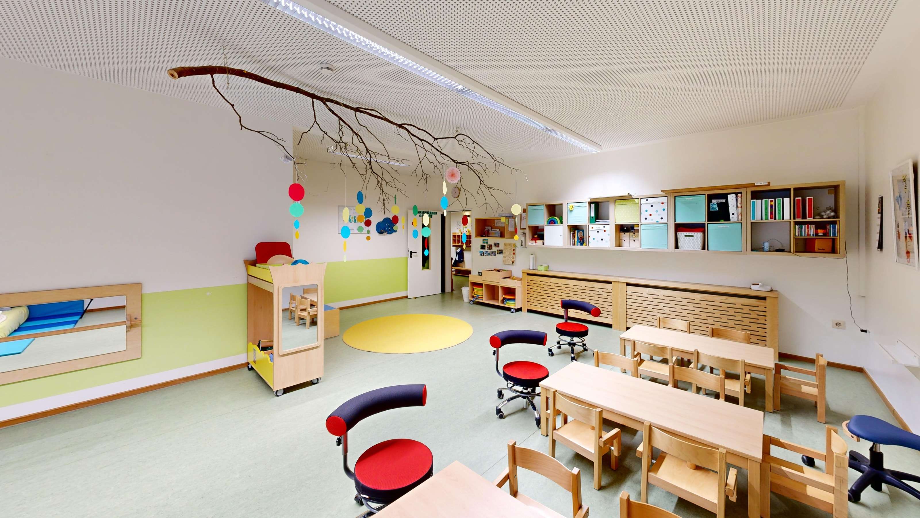 Gruppenraum einer Kindertagesstätte mit Holzmöbeln