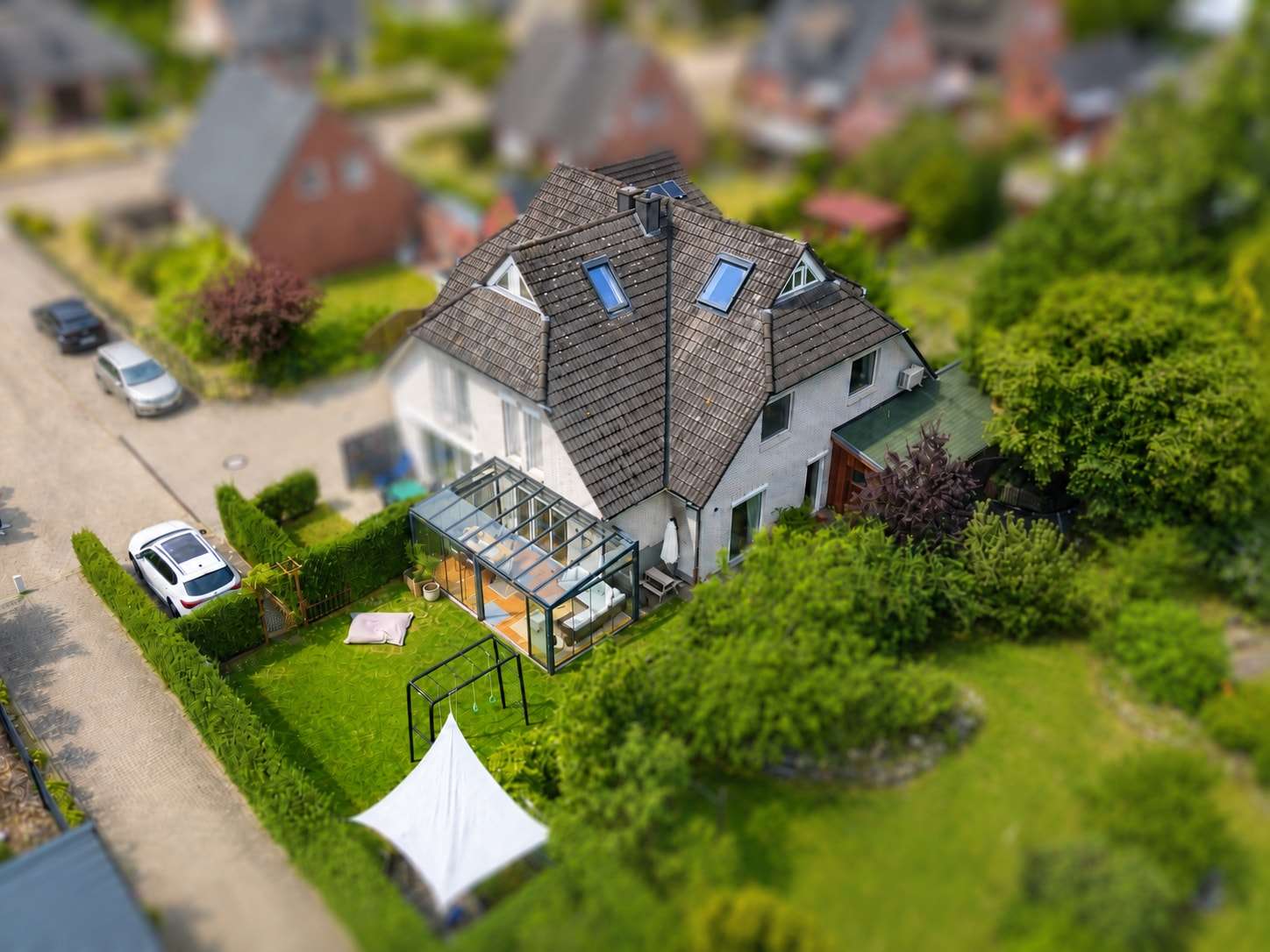 Luftaufnahme eines Wohnhauses mit Wintergarten und großem Garten